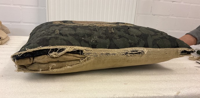 Seitenansicht eines der Kissen im Vorzustand mit aufgeplatzter Naht © Stadtmuseum Münster