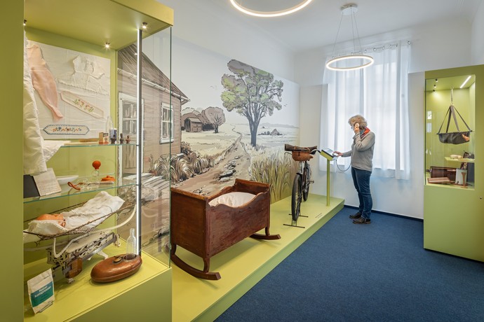 Eine Frau hört sich an einer Medienstation im Museum Villa Medica etwas an. Foto: Jannis Wiebusch