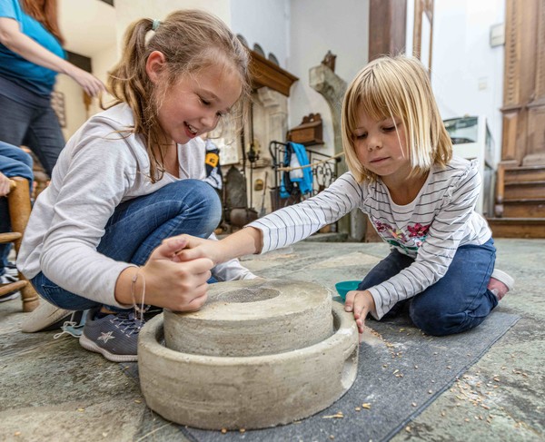 Kinder beim Kornmahlen, Foto: LWL/Walter Fischer